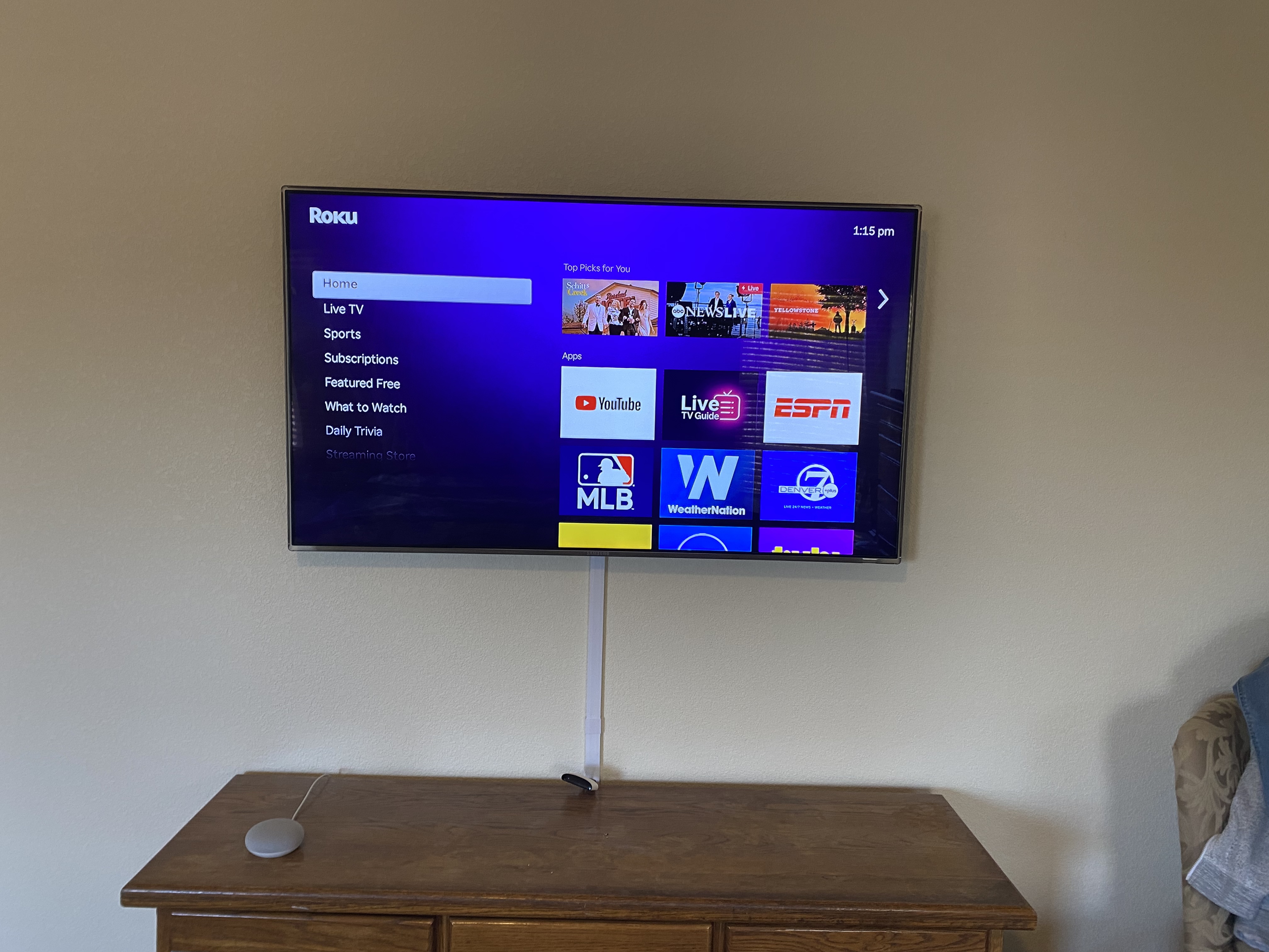 TV mounted on wall with surround sound speakers