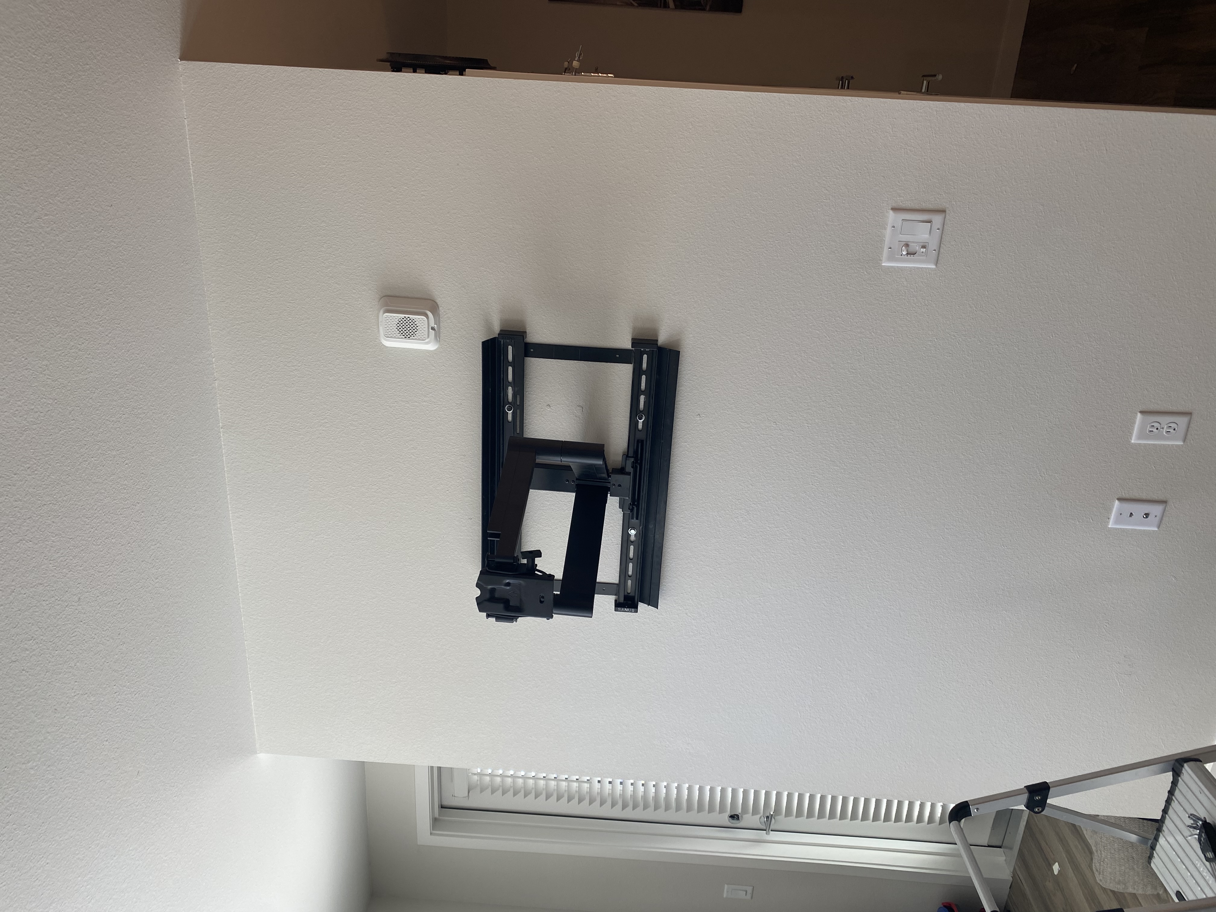 Full motion TV wall bracket installed on drywall